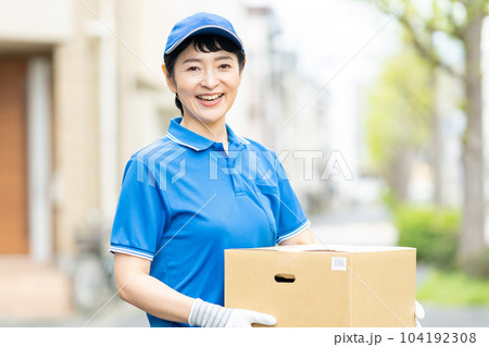 荷物を届けるドライバーの女性 荷物を届けるドライバーの女性 104192308