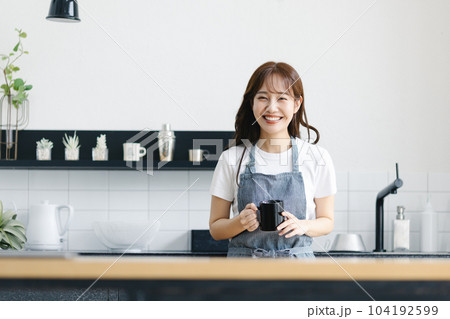 キッチンでコーヒーを飲む女性 104192599