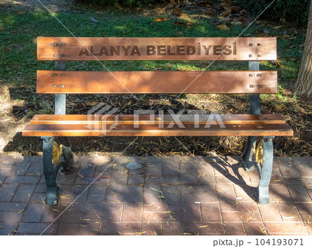 Alanya, Turkey - Nov 3, 2022. Bench in a city park, in patches of sunlight 104193071