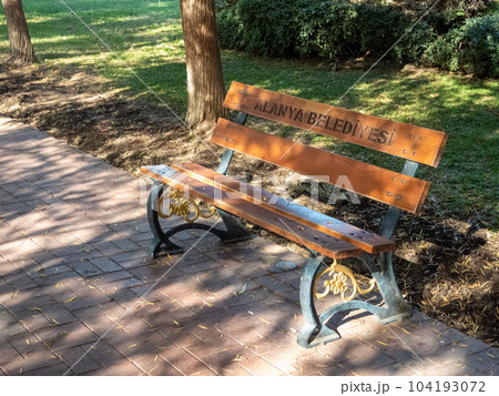 Alanya, Turkey - Nov 3, 2022. Bench in a city park, in patches of sunlight 104193072