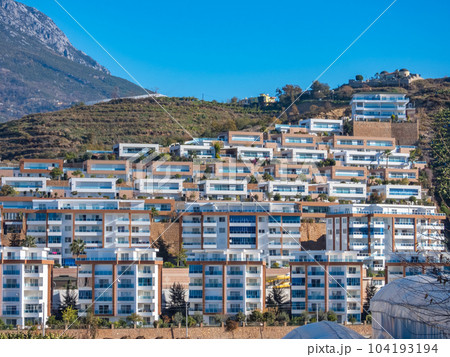 Alanya, Turkey - Jan 4, 2023. Modern residential buildings on a hillside against the backdrop of the Taurus Mountains 104193194