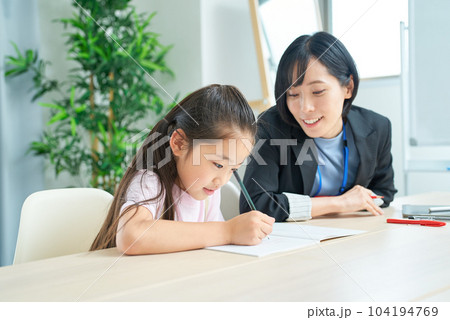 勉強する女の子とサポートするスーツ姿の女性 勉強する女の子とサポートするスーツ姿の女性 104194769