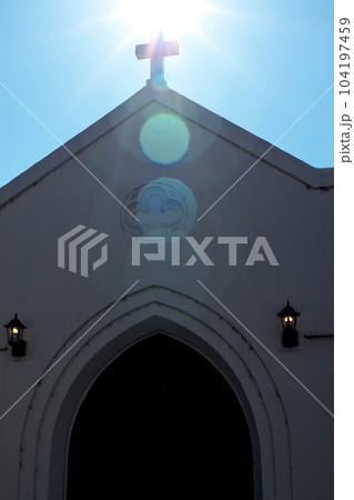 太陽の逆光に光る教会の屋根の十字架 太陽の逆光に光る教会の屋根の十字架 104197459
