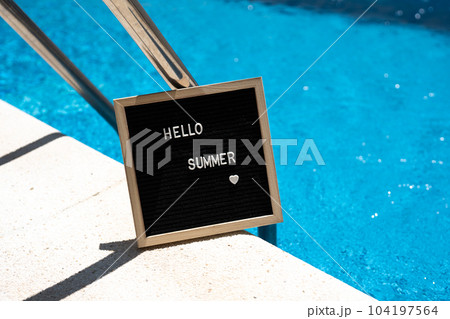 Hello summer text on chalkboard on pool background on summer sunny day. 104197564