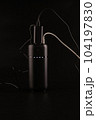 powerbank black on a black background, usb cables, plug, light and reflection 104197830