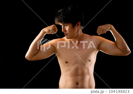 Young confident Asian man shirtless posing rising two arms muscle 104198823