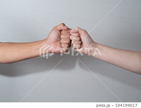 拳を合わせる二人 104199017