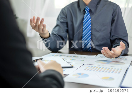 Two business leaders talk about charts, financial graphs showing results are analyzing and calculating planning strategies, business success building processes Two business leaders talk about charts, financial graphs showing results are analyzing and calculating planning strategies, business success building processes 104199572