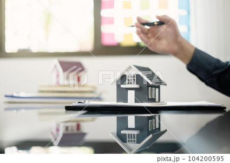 Agents working in real estate investment and home insurance signing contracts in accordance with the home buying insurance agreements approving purchases for clients 104200595