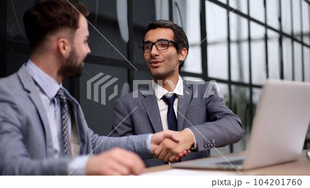 Two Businessmen Having Meeting Around Table In Modern Office 104201760