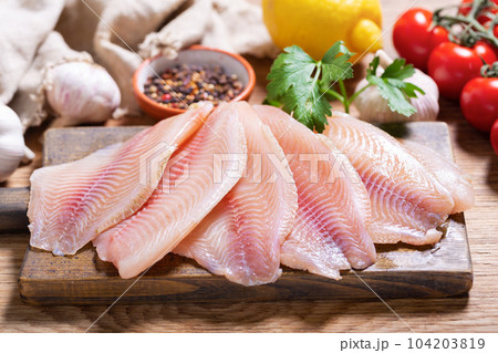fresh fish fillet of tilapia with ingredients for cooking 104203819