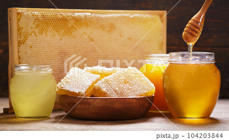 Various types of honey in glass jars and honeycomb Various types of honey in glass jars and honeycomb 104203844