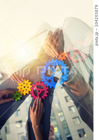 Handshaking between businessmen. Teamwork with colored gears. Double exposure with modern office Handshaking between businessmen. Teamwork with colored gears. Double exposure with modern office 104203879