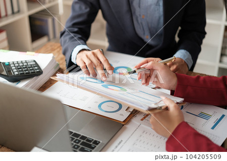 Team of two asian male and female business people working together discussing new financial graph data on office table with laptop and digital tablet. Team of two asian male and female business people working together discussing new financial graph data on office table with laptop and digital tablet. 104205509