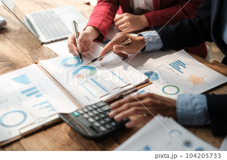 Team of two asian male and female business people working together discussing new financial graph data on office table with laptop and digital tablet. 104205733