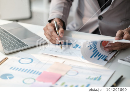 Close up young man with calculator counting making notes at home, hand is writing in a notebook. Savings finances concept 104205860