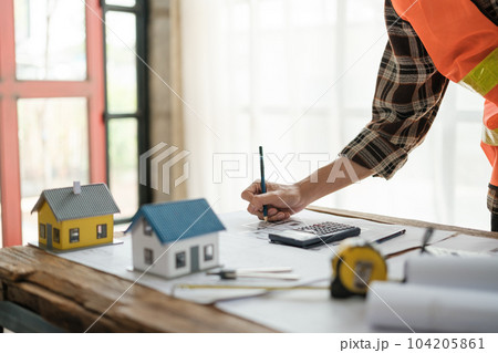 Construction engineer working at blueprint to build a home. 104205861