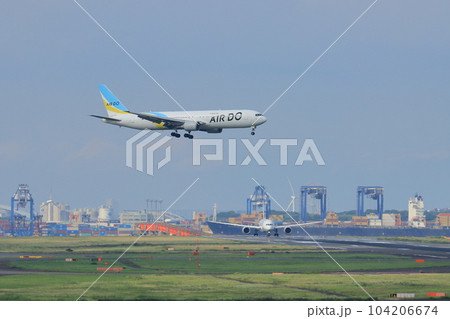 東京の都市を背景に着陸する旅客機　羽田空港に着陸する旅客機 104206674