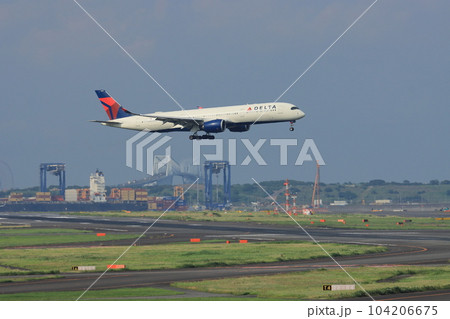 東京の都市を背景に着陸する旅客機　羽田空港に着陸する旅客機 104206675