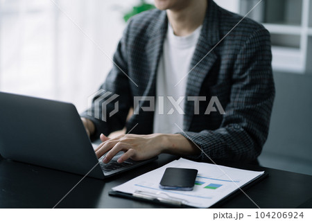 Business man working at office with laptop and documents on his desk, financial adviser analyzing data. 104206924