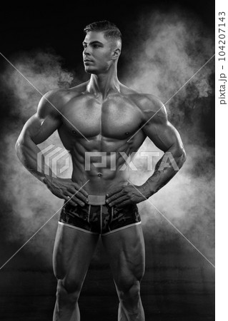 Bodybuilder showing off his perfect low fat body without clothes in studio 104207143