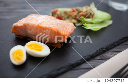 baked salmon fillet with homemade guacamole and quail eggs halves baked salmon fillet with homemade guacamole and quail eggs halves 104207713