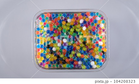 Water beads in box top view, abstract background. Texture of Hydrogel balls or many colorful orbeez for wallpaper. 104208323