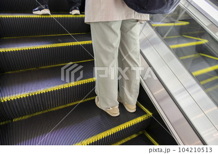 エスカレーターに乗る女性の足元 エスカレーターに乗る女性の足元 104210513