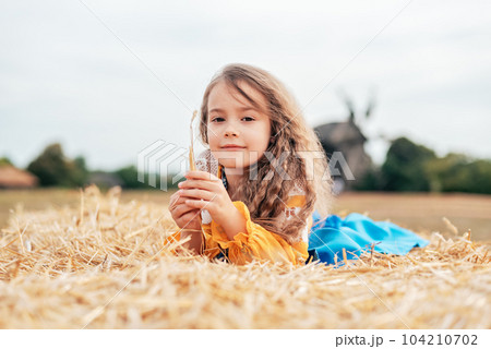 Ukraine's Independence Flag Day. Girl in traditional embroidery with flag of Ukraine in field. Constitution day. 24 August. Patriotic holiday. Ukraine's Independence Flag Day. Girl in traditional embroidery with flag of Ukraine in field. Constitution day. 24 August. Patriotic holiday. 104210702