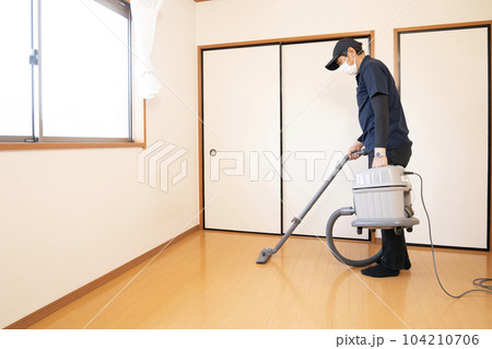 片付けた部屋に掃除機をかける男性作業員 片付けた部屋に掃除機をかける男性作業員 104210706