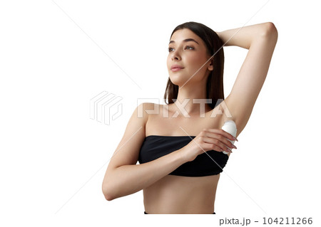 Portrait of beautiful young woman with well-kept skin using deodorant stick for freshness against white studio background Portrait of beautiful young woman with well-kept skin using deodorant stick for freshness against white studio background 104211266