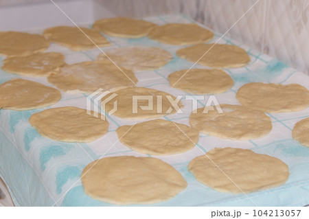 Many pieces of rolled dough for pies on a napkin on the table in the kitchen 104213057