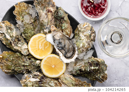 Fresh oysters with sauce and lemons Fresh oysters with sauce and lemons 104214265