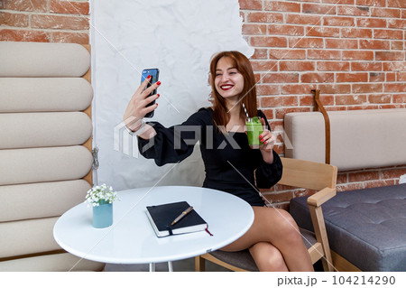 The girl in the cafe shows a funny face. The girl in the cafe shows a funny face. 104214290