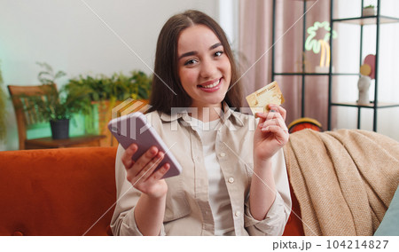 Young woman using credit bank card and smartphone, transferring money purchases online shopping 104214827