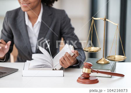 Lawyer office. Statue of Justice with scales and lawyer working on a laptop. Legal law, advice and justice concept. Lawyer office. Statue of Justice with scales and lawyer working on a laptop. Legal law, advice and justice concept. 104216073