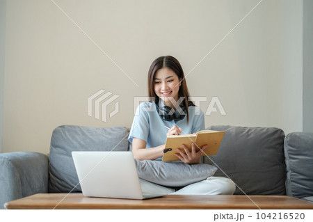Beautiful asian woman online learning with laptop in living room. Beautiful asian woman online learning with laptop in living room. 104216520