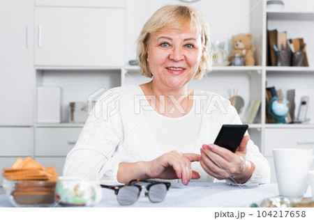 Mature woman with smartphone Mature woman with smartphone 104217658