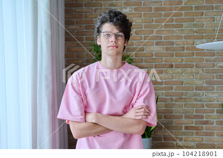 Portrait of handsome guy 18, 19 years old with crossed arms in home interior 104218901