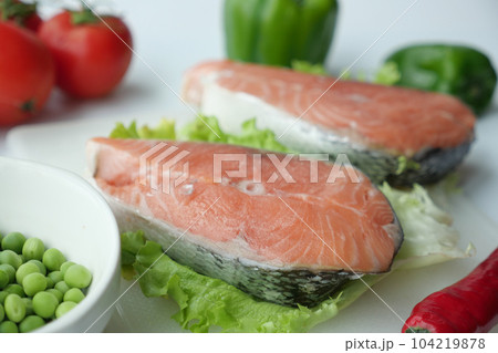 Raw, fresh salmon steak and vegetables on white  104219878