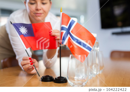 Little flag of Norway on table and flag of Taiwan put next to it by young woman 104222422