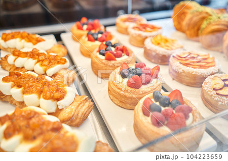 fresh pastries with berries. A variety of fresh pastries in the bakery window. almond croissant is fresh and hot in a cafe next to other types of pastries. The interior of an Italian restaurant. 104223659