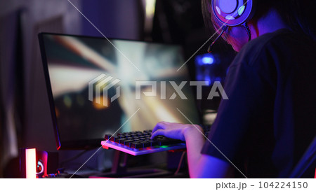 Female cyber hacker gamer pressing on keyboard to competition and playing games on computer 104224150