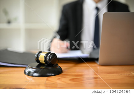 Close-up image of a judge gavel or judge hammer is on a wooden desk in a lawyer office. Close-up image of a judge gavel or judge hammer is on a wooden desk in a lawyer office. 104224564