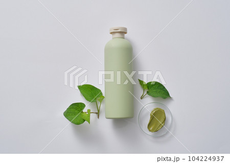 Pastel bottle without label decorated with few fish mint leaves and green texture. Fish mint (Houttuynia cordata) can increase the production of red blood cells Pastel bottle without label decorated with few fish mint leaves and green texture. Fish mint (Houttuynia cordata) can increase the production of red blood cells 104224937