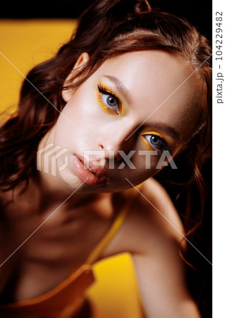 Young Adult Woman with Long Red Hair and Confident Look in Studio Portrait 104229482