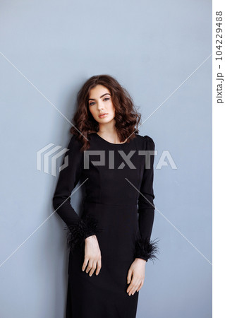 Portrait of a young beautiful brunette in black 104229488