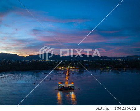 aerial photography cloud above Palai pier at beautiful sunset..Palai pier is next to Chalong pier..fishing boats parking on the beach..colorful cloud above the mountain range background.. aerial photography cloud above Palai pier at beautiful sunset..Palai pier is next to Chalong pier..fishing boats parking on the beach..colorful cloud above the mountain range background.. 104230652