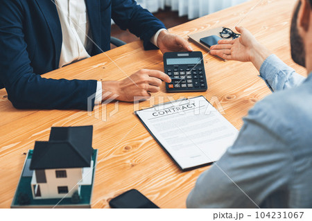 Real estate agent calculating tax and interest with calculator. Entity Real estate agent calculating tax and interest with calculator. Entity 104231067