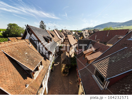 Aerial Shot of Street in Eguisheim village in the Alsace province, France. Picturesque village in a Sunny Summer Day Aerial Shot of Street in Eguisheim village in the Alsace province, France. Picturesque village in a Sunny Summer Day 104232571